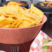 A large round polyethylene basket of tortilla chips on a table in a Mexican restaurant.