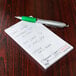 A green pen on a white Choice guest check pad.