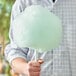 A man holding a large cotton candy on a paper cone.