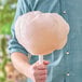 A person holding a large cotton candy made with Great Western orange cotton candy sugar.