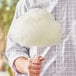 A man's hand holding a cotton candy made with Great Western apple cotton candy floss.
