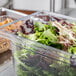 A Vollrath clear polycarbonate food pan with lettuce in it.