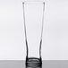 A Libbey Pinnacle Pilsner glass with a black rim on a table.