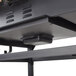 A black rectangular Backyard Pro portable outdoor gas and charcoal grill on a black metal shelf.