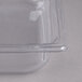 A Vollrath clear polycarbonate food pan with a lid on a counter.
