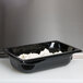 A black Vollrath plastic food pan with food in it.