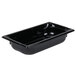 A Vollrath black polycarbonate food pan on a white counter.