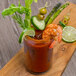 A glass of Chincoteague Bloody Mary Mix garnished with shrimp and vegetables.