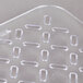 A close-up of a Vollrath clear plastic drain tray with holes.
