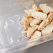 A Vollrath clear polycarbonate food pan drain tray filled with chicken pieces.
