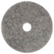 A grey circular Scrubble heavy burnishing floor pad with a hole in the center.