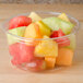 A close up of a bowl of sliced fruit in a Bare by Solo clear deli container.