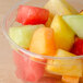 A bowl of sliced fruit in a Bare by Solo clear plastic deli container.