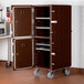 A dark brown Cambro Camcart with two doors and metal shelves.