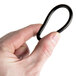 A hand holding a black rubber O ring.