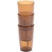 A stack of three Cambro amber plastic tumblers.