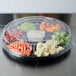 A Fineline clear plastic round low dome lid on a container of vegetables