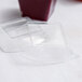A clear plastic container with a clear dome lid filled with a red liquid.