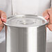 A person holding a Vollrath stainless steel Bain Marie cover.