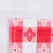 A red and white checkered vinyl table cover with a flannel back.