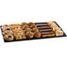 A Tablecraft black metal rectangular platter on a counter with assorted pastries.