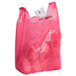 A pink plastic 1/6 size medium-duty T-shirt bag with handles.