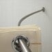 A Crescent Suite stainless steel curved shower curtain rod with a white towel hanging on it.