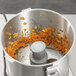 A Robot Coupe R401 food processor filled with orange pieces.