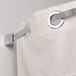 A white shower curtain hanging from a curved aluminum rod with brushed nickel ends.