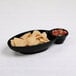 A black melamine tray with food in a bowl of chips.