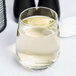 A Libbey stemless white wine glass filled with white wine on a table.