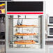 A Hatco Flav-R-Savor pizza display case with pizzas on a rack.