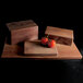 A rectangular faux walnut melamine riser with tomatoes on wooden blocks.