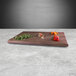 An Elite Global Solutions rectangular faux walnut melamine modular riser with chopped vegetables on it.