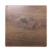 A close up of an Elite Global Solutions faux walnut melamine serving board on a table with a knot in the wood.