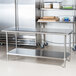 A stainless steel Advance Tabco work table with undershelf in a kitchen.