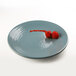 An Elite Global Solutions round melamine plate in Abyss color with strawberries on it.