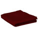 A folded burgundy table cover on a white background.