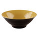 An olive oil-colored bowl with a yellow rim and black speckles.