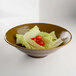 An Elite Global Solutions Pebble Creek Tapenade-colored melamine bowl filled with lettuce and tomatoes.