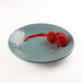 An Elite Global Solutions Pebble Creek Abyss-colored melamine plate with a strawberry and a rose on it.