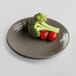 An Elite Global Solutions round melamine plate in mushroom color with broccoli and tomatoes on it.