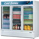 A Turbo Air white three section glass door merchandising refrigerator filled with drinks.