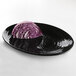 A piece of red cabbage on a black Elite Global Solutions oval platter.