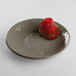 A mushroom-colored Elite Global Solutions round melamine plate with a strawberry on it.