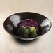 An Elite Global Solutions Pebble Creek aubergine melamine bowl filled with broccoli and cabbage.
