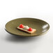 An Elite Global Solutions Lizard-colored melamine plate with two pieces of bread and a tomato on it.