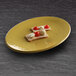 An olive oil-colored Elite Global Solutions oval platter with food on it.
