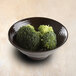 A bowl of broccoli in an aubergine-colored melamine bowl.