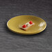 An olive oil-colored Elite Global Solutions round melamine plate with food on it.